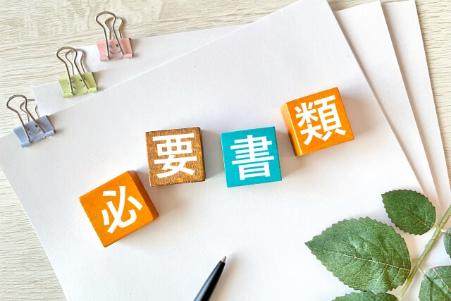 必要書類を示す積み木とペン
